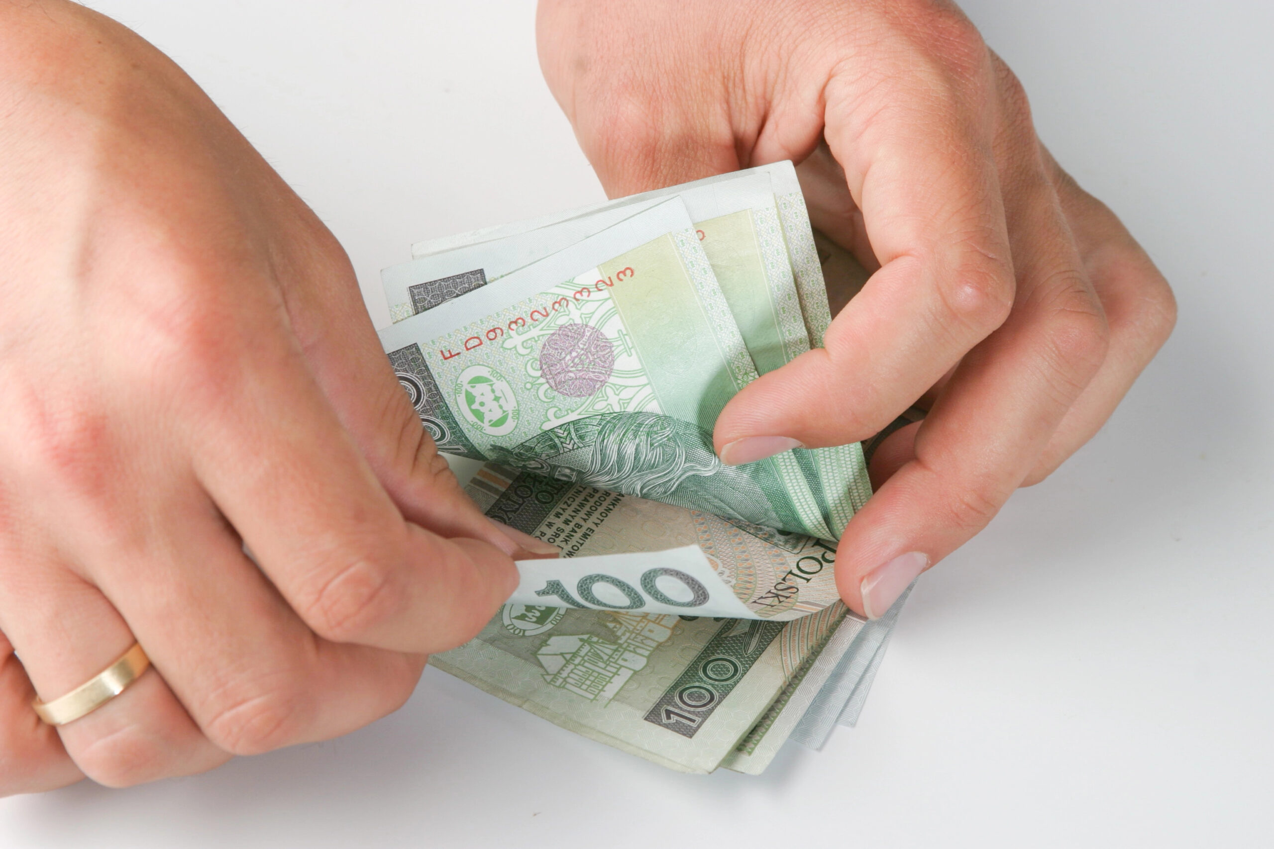 bliżenie na ręce trzymające banknoty, symbolizujące finansowanie i dotacje dla fundacji.